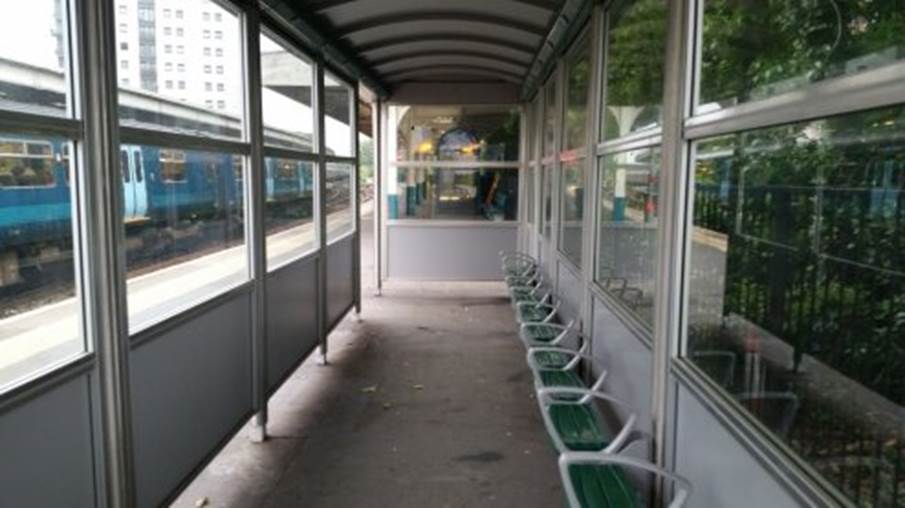 A bus stop with green chairs

Description automatically generated
